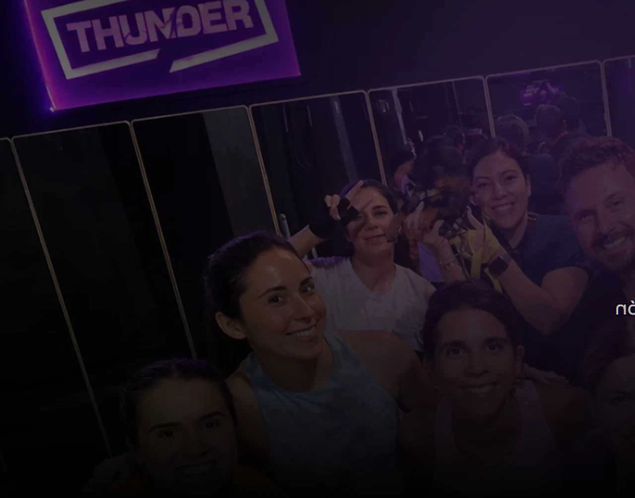 Selfie del grupo de Thunder bajo el letrero de neón